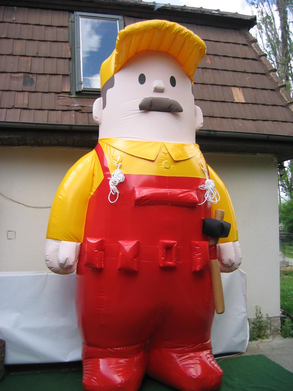 Inflatable handyman figure in a yellow cap and red overalls